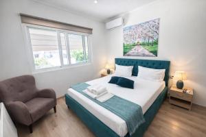 a bedroom with a large bed and a chair at Liovore Apartments in Lygia