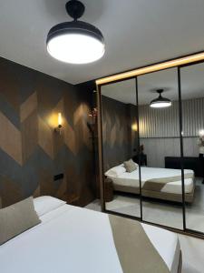a bedroom with two beds and a mirror at Panorama Nacional in Ávila