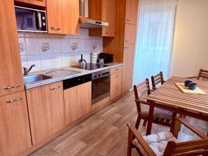 a kitchen with wooden cabinets and a table with a dining room at Le Cosy Home in Guebwiller
