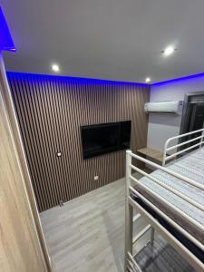 a room with a flat screen tv on a wall at Habitaciones privadas in Madrid