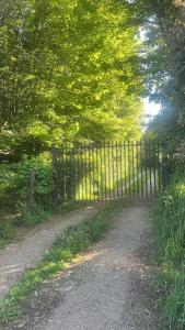 a gate on a dirt road next to trees at Casa Krampus Hospedaje y Cervecería in Valdivia