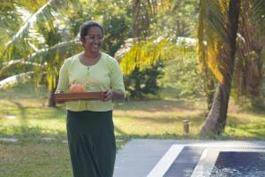 a woman standing on a street holding a box at Welpalla Signature in Welpalla