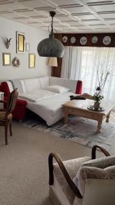 a bedroom with a large white bed and a table at PrivArtZimmer 'Ausfahrt freihalten' in Husum