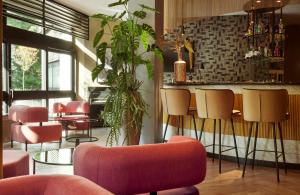 a restaurant with pink chairs and a bar at Leonardo Royal Hotel Baden- Baden in Baden-Baden