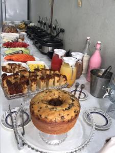 a table with a cake and other food on it at Pousada Pergentino in Maceió +20 photos