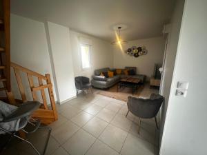 a living room with a couch and a table and chairs at Maison individuelle parking privé et gratuit in Sainte-Savine