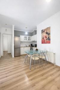a dining room with a glass table and a kitchen at Liovore Apartments in Lygia