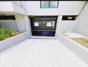 a garage with a black gate in a white building at Flat Completo Porto de galinhas in Porto De Galinhas +3 photos