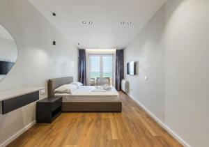 a bedroom with a large bed and a large window at The Seaview Jacuzzi Suite by PS in Golem