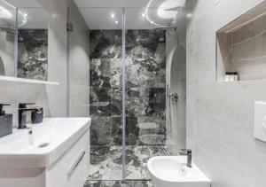 a white bathroom with a sink and a shower at The Seaview Jacuzzi Suite by PS in Golem +21 photos