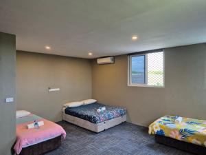 a room with two beds and a window at Island Accommodation Nadi in Nadi