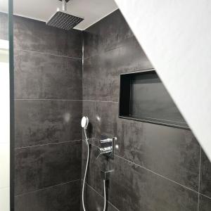 a black bathroom with a shower with a hose at casa stadio2 in Leverkusen