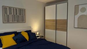 a bedroom with a bed with blue and yellow pillows at Apartmán Jungmannka in Bruntál +10 photos