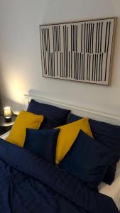a bed with blue and yellow pillows on it at Apartmán Jungmannka in Bruntál