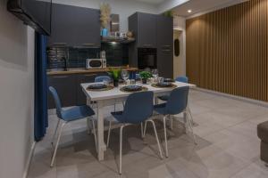 a kitchen with a white table and blue chairs at Bastioni Central Apartment in Civitavecchia +12 photos