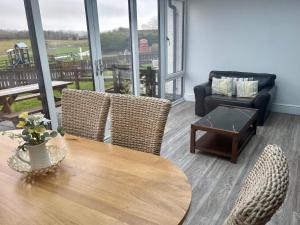 a living room with a table and chairs and a couch at The Milking Parlour in Aberystwyth