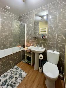 a bathroom with a toilet and a sink and a tub at Pod Modrzewiem in Pogorzelce