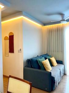 a blue couch in a room with a window at Solar Aruana, Aracaju, Aeroporto, Orla de Atalaia e Praia in Aracaju +12 photos