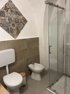a bathroom with a toilet and a glass shower at F&F Room in Sassari +9 photos