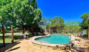 a swimming pool in a yard with chairs and a fence at Rusty Rio in Concan