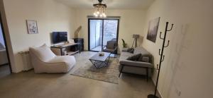 a living room with two couches and a tv at Domaine De Faraya F2 in Nab‘ al Maghārah