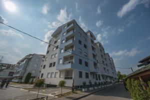 a tall white building on the side of a street at Apartman TRI KRALJA 4 in Banja Koviljača