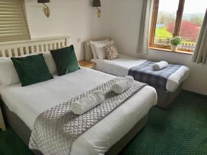 a room with two beds and a window at The Milking Parlour in Aberystwyth