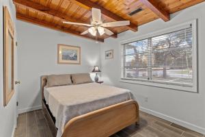 a bedroom with a bed and a ceiling fan at Pool, Blocks away from Beach, Dog friendly in Oak Island