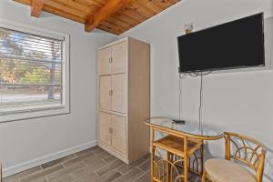 a room with a table and a tv on a wall at Pool, Blocks away from Beach, Dog friendly in Oak Island