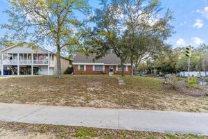a house with a large yard in front of it at Pool, Blocks away from Beach, Dog friendly in Oak Island
