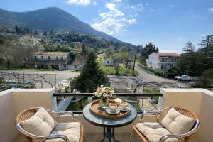 a balcony with a table and chairs and a mountain at Ameli Studio ,Balcony with Mountain View, Kitchenette, 1km to Beach by likeyourhome in Corfu