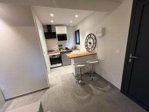 a small kitchen with a counter and stools in it at Studio neuf au calme proche Grenoble in Saint-Ismier