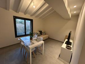 a living room with a white table and a tv at Studio neuf au calme proche Grenoble in Saint-Ismier