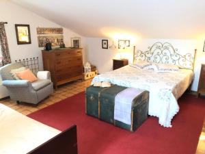 a bedroom with a large bed and a chair at Una casa ospitale con giardino in Castel SantʼAngelo