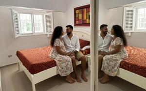 a group of three people sitting on a bed at Habitat Samaná Apartments - Coral Samanà in Los Corozos