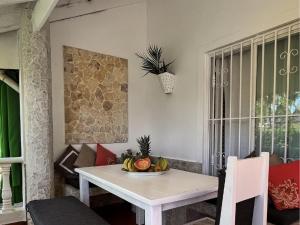 a dining room table with a bowl of fruit on it at Habitat Samaná Apartments - Coral Samanà in Los Corozos