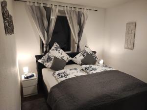 a bedroom with a bed with pillows and a window at Apartment For You in Hameln