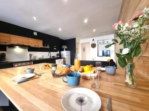 a kitchen with a wooden table with a vase of flowers at L'escale Charliendine in Charlieu