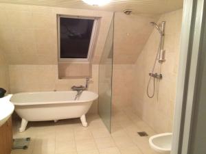 a bathroom with a tub and a sink and a shower at Lille værelse på 1 sal in Kolding