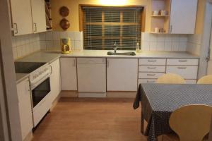 a kitchen with white cabinets and a table with a tableablish at Lille værelse på 1 sal in Kolding