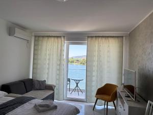 a bedroom with a window with a view of the water at Apartman studio BMB 1 in Bukorovac +1 photo