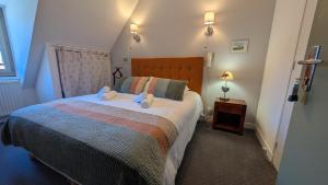 a bedroom with a bed with two stuffed animals on it at Hôtel Restaurant du Plomb du Cantal in Murat