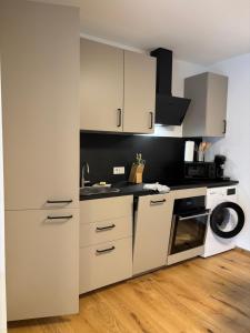 a kitchen with white cabinets and a washing machine at Apartment Leitner in Haiming