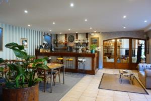 a living room with a table and a bar at Hôtel Restaurant du Plomb du Cantal in Murat