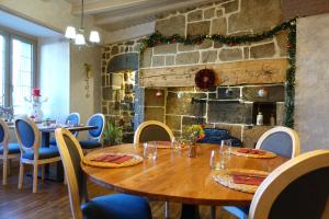 a dining room with a wooden table and chairs at Hôtel Restaurant du Plomb du Cantal in Murat +47 photos