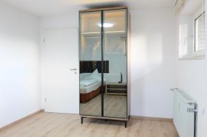 ein gläserner Aufzug in einem weißen Raum mit einem Bett in der Unterkunft Bronsliving in Schleiden