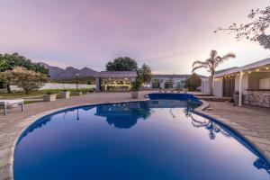 a swimming pool in the backyard of a home with a house at LEO Sky Farm Cottages in Simondium