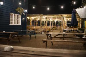 a group of picnic tables outside of a building at night at Ye Olde Crown in Edenbridge