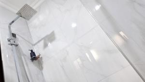 a person standing on the glass wall of a building at Witu Apartments in Lusaka +8 photos