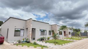 a white house with a car parked in front of it at Witu Apartments in Lusaka